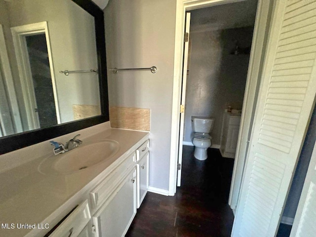 540 Woodland Hills Pl, Jackson, MS 39216 - bathroom with toilet, vanity, baseboards, and wood finished floors