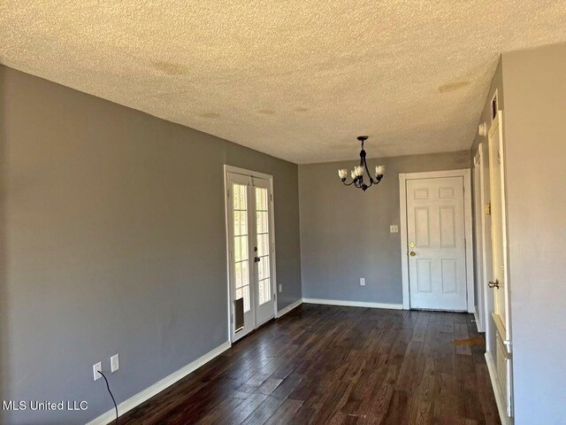 540 Woodland Hills Pl, Jackson, MS 39216 - spare room featuring dark wood finished floors, french doors, baseboards, and an inviting chandelier