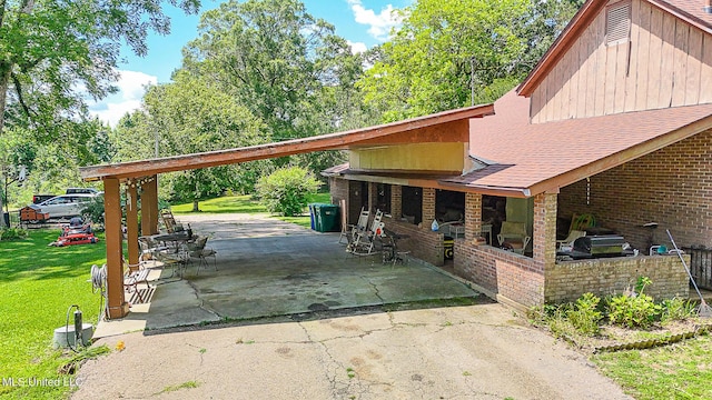2548 Furrs Mill Dr, Wesson, MS 39191 - view of side of property featuring driveway, a patio, brick siding, a carport, and a lawn