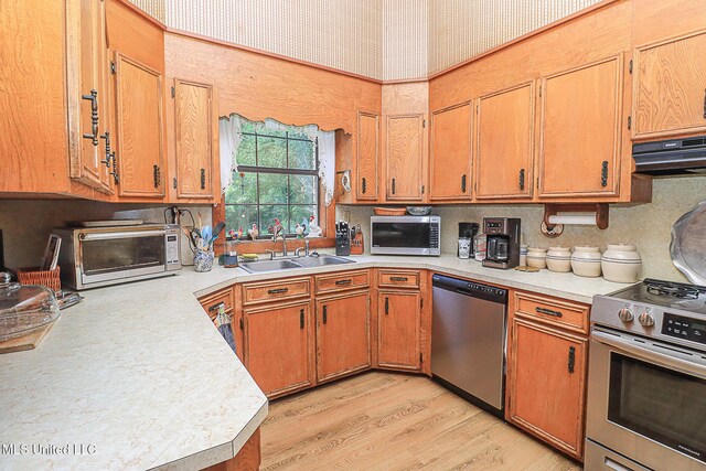 2548 Furrs Mill Dr, Wesson, MS 39191 - kitchen with appliances with stainless steel finishes, a sink, light countertops, under cabinet range hood, and light wood-style flooring