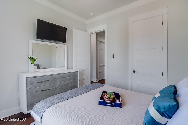 bedroom featuring crown molding and dark hardwood / wood-style floors