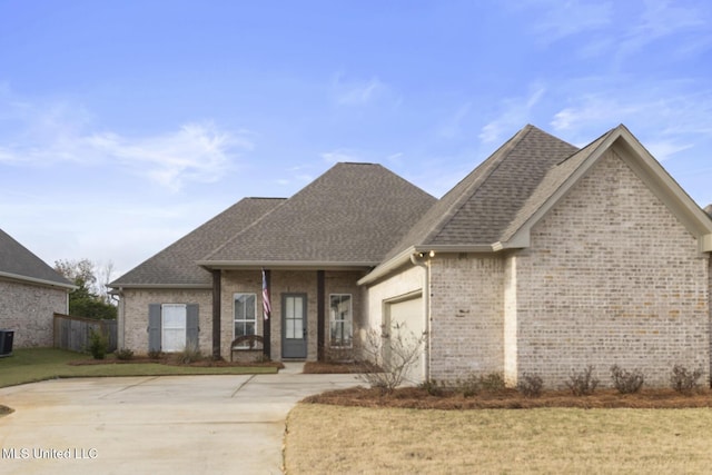 view of front of property featuring a garage, a front lawn, and central air condition unit