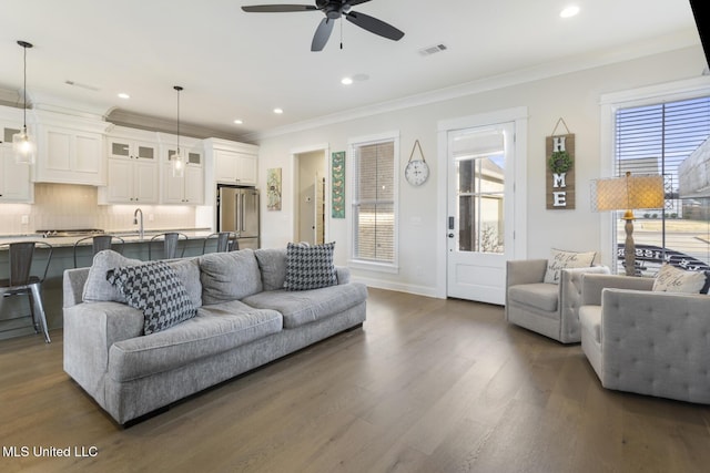 living room featuring ornamental molding, ceiling fan, dark wood-type flooring, and sink