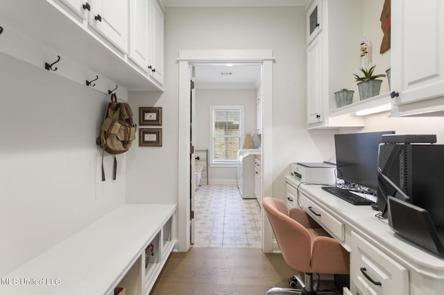 office with washer and clothes dryer, built in desk, crown molding, and light hardwood / wood-style flooring