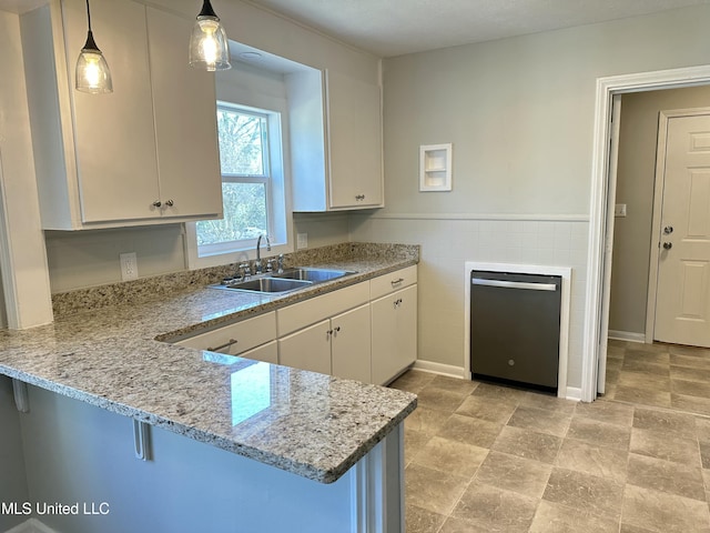 kitchen featuring a breakfast bar, white cabinets, sink, decorative light fixtures, and kitchen peninsula