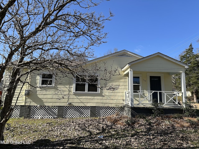 view of side of home featuring covered porch