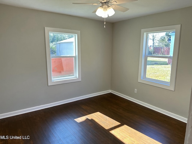 empty room with a wealth of natural light, ceiling fan, and dark hardwood / wood-style floors