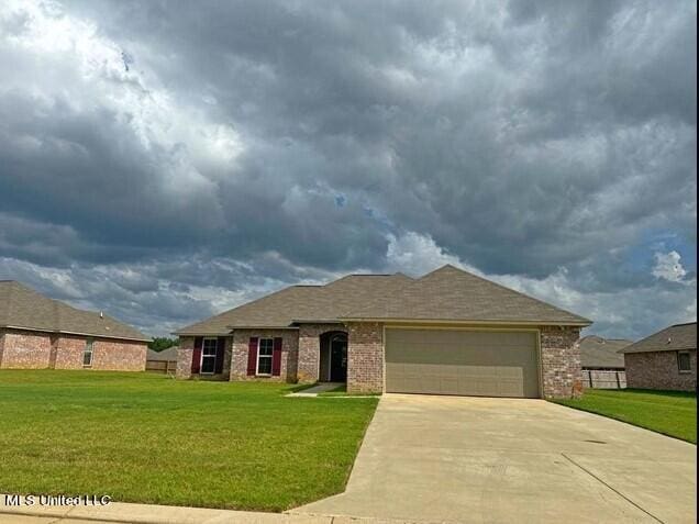 single story home featuring driveway, brick siding, a front lawn, and a garage