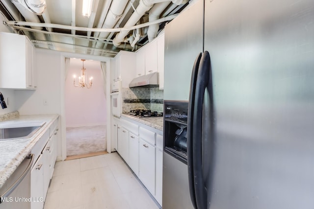 2512 Randall Dr, Biloxi, MS 39531 - kitchen featuring stainless steel appliances, under cabinet range hood, a chandelier, and white cabinets