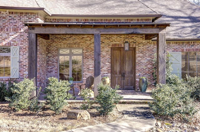 view of exterior entry featuring covered porch