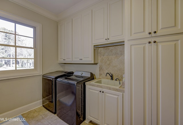 washroom with light tile patterned flooring, washer and dryer, sink, cabinets, and crown molding