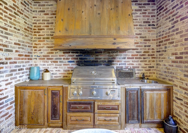 kitchen with brick wall and tile counters