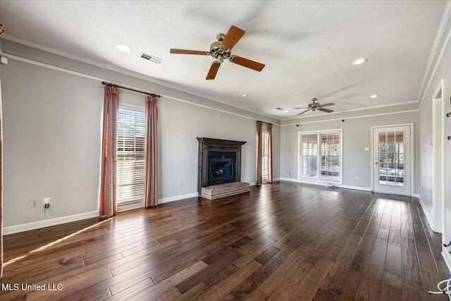 unfurnished living room with a textured ceiling, dark hardwood / wood-style floors, a brick fireplace, and ceiling fan