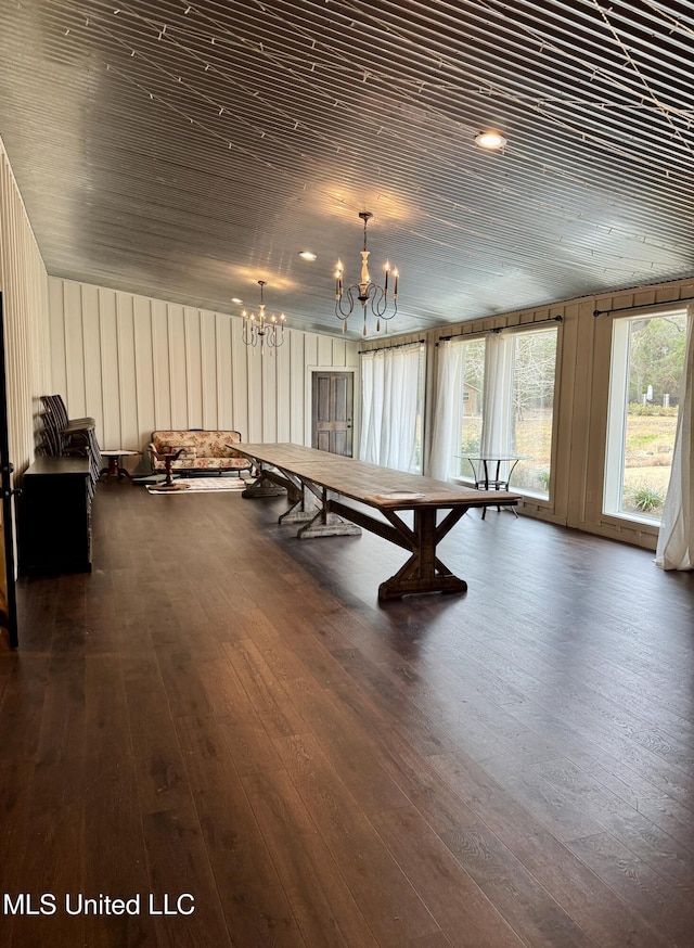 recreation room featuring a notable chandelier, dark wood-type flooring, and wooden ceiling