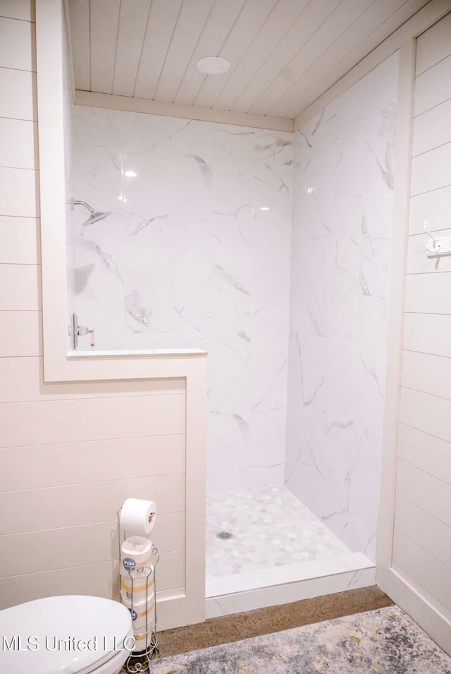 bathroom with toilet and a tile shower