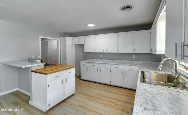 5887 Scotland Rd, Bentonia, MS 39040 - kitchen featuring a sink, white cabinetry, and light wood-type flooring
