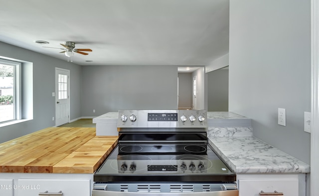5887 Scotland Rd, Bentonia, MS 39040 - kitchen featuring stainless steel electric stove, a ceiling fan, and white cabinetry