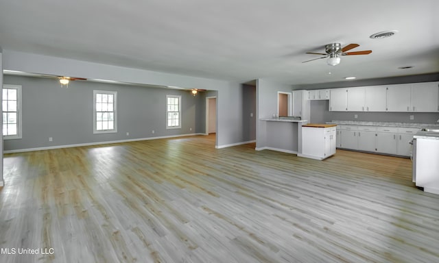 5887 Scotland Rd, Bentonia, MS 39040 - kitchen with ceiling fan, open floor plan, white cabinets, and baseboards