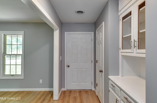 5887 Scotland Rd, Bentonia, MS 39040 - doorway to outside featuring light wood-type flooring, plenty of natural light, and baseboards