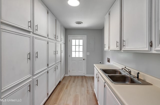 5887 Scotland Rd, Bentonia, MS 39040 - kitchen featuring a sink, light wood-style flooring, white cabinetry, and light countertops