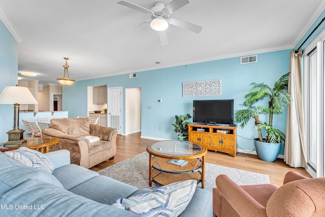 living room featuring light wood-type flooring, ceiling fan, and crown molding