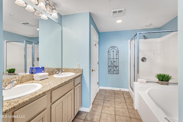 bathroom featuring plus walk in shower, vanity, and tile patterned floors