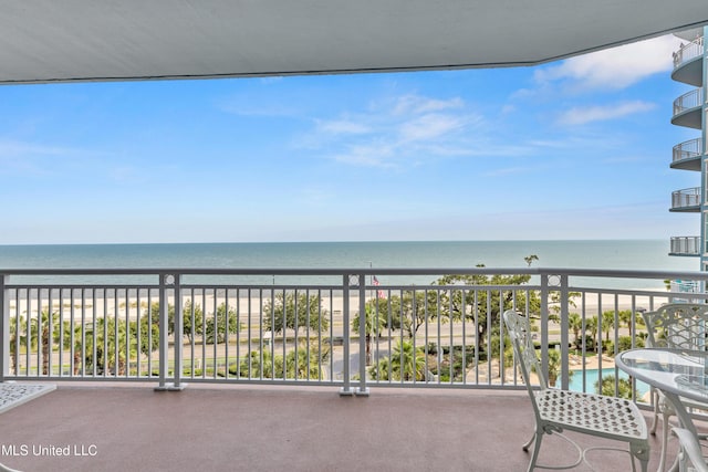 balcony featuring a view of the beach and a water view