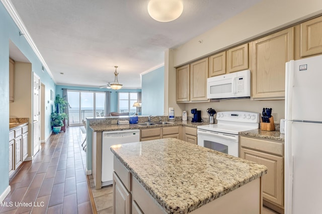 kitchen with kitchen peninsula, a kitchen island, hanging light fixtures, and white appliances