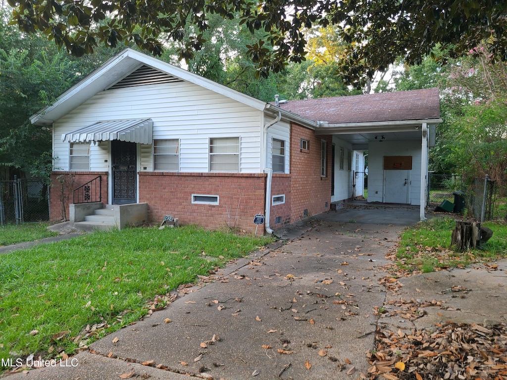 view of front of house with a carport and a front yard