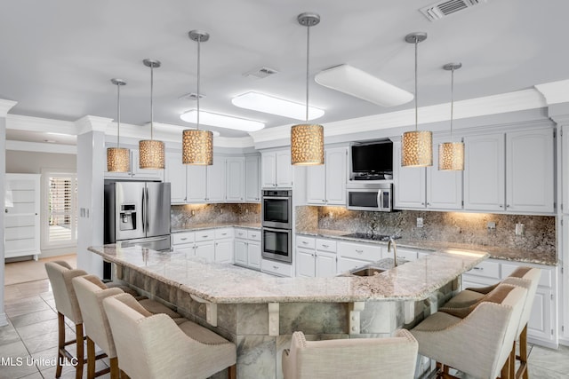 7528 Crooked Stick Dr, Diamondhead, MS 39525 - kitchen featuring appliances with stainless steel finishes, crown molding, a breakfast bar area, tasteful backsplash, and pendant lighting