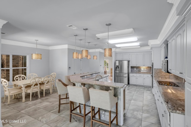 7528 Crooked Stick Dr, Diamondhead, MS 39525 - kitchen featuring stainless steel appliances, light marble finish flooring, a breakfast bar, tasteful backsplash, and light stone counters