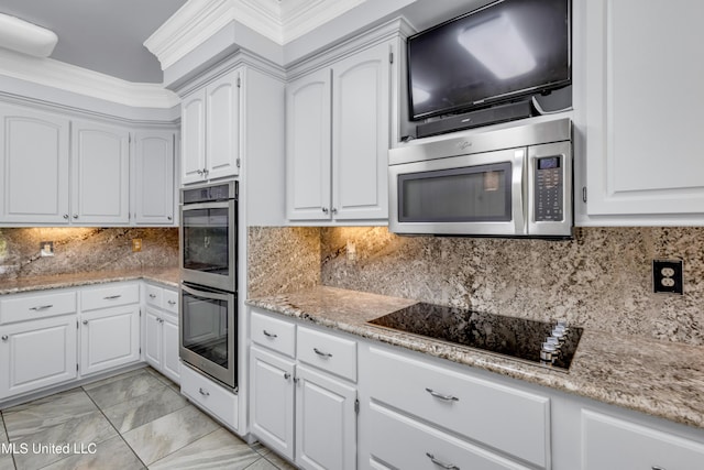 7528 Crooked Stick Dr, Diamondhead, MS 39525 - kitchen with appliances with stainless steel finishes, white cabinetry, light stone countertops, and backsplash