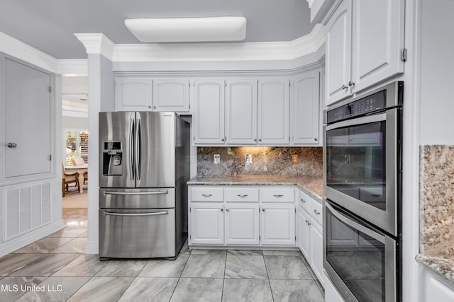 7528 Crooked Stick Dr, Diamondhead, MS 39525 - kitchen featuring appliances with stainless steel finishes, white cabinets, light stone counters, light marble finish floors, and crown molding