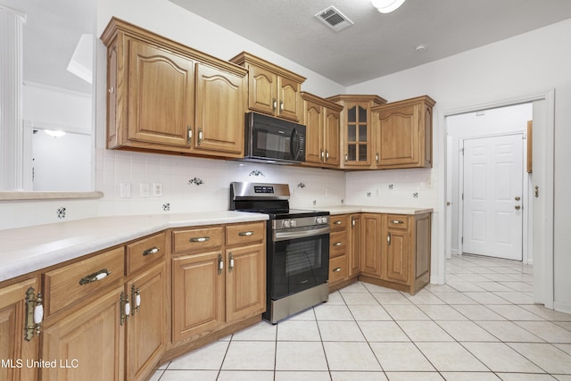 kitchen featuring stainless steel range with electric stovetop, backsplash, and light tile patterned floors