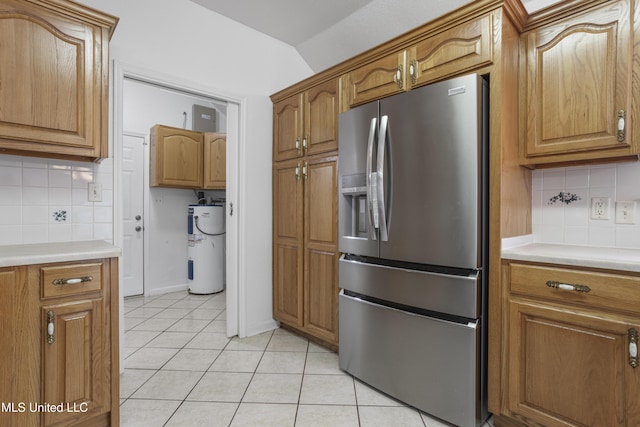 kitchen with tasteful backsplash, stainless steel fridge with ice dispenser, water heater, and light tile patterned floors