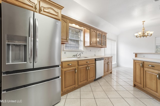 kitchen with sink, light tile patterned floors, an inviting chandelier, stainless steel appliances, and decorative backsplash