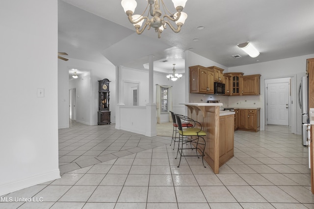 kitchen with an inviting chandelier, range, a breakfast bar, and light tile patterned flooring