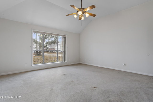 carpeted spare room with ceiling fan and vaulted ceiling