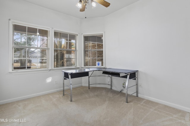 carpeted office space featuring ceiling fan