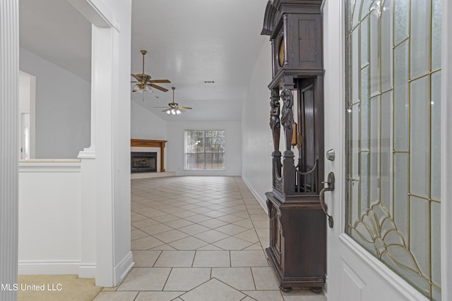 tiled foyer entrance with ceiling fan and vaulted ceiling