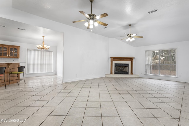 unfurnished living room featuring lofted ceiling, ceiling fan with notable chandelier, a fireplace, and plenty of natural light