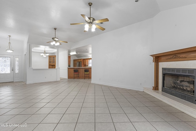 unfurnished living room with lofted ceiling, light tile patterned floors, ceiling fan with notable chandelier, and a fireplace