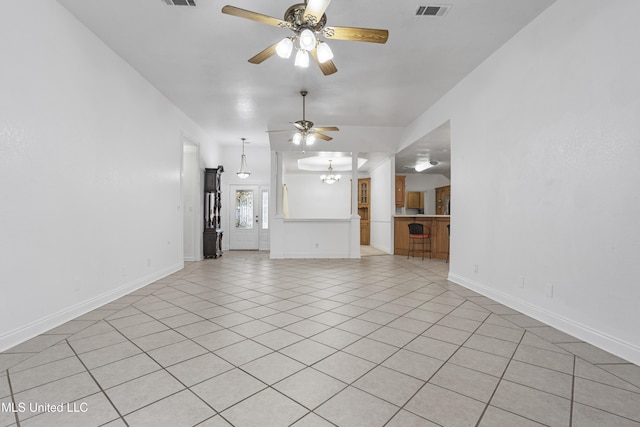 unfurnished living room with ceiling fan with notable chandelier and light tile patterned floors