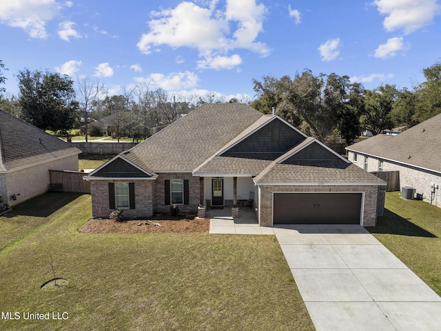 craftsman house with a front yard, concrete driveway, and roof with shingles