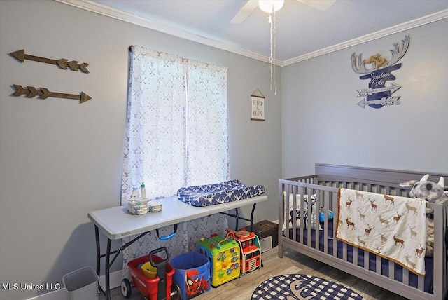 560 Bailey St, Mendenhall, MS 39114 - bedroom featuring crown molding, a crib, wood finished floors, and ceiling fan
