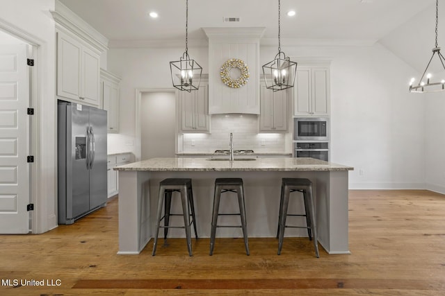 kitchen featuring a notable chandelier, visible vents, decorative backsplash, appliances with stainless steel finishes, and a sink