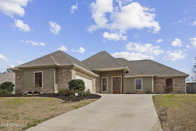 view of front facade featuring a garage, driveway, roof with shingles, a front lawn, and brick siding