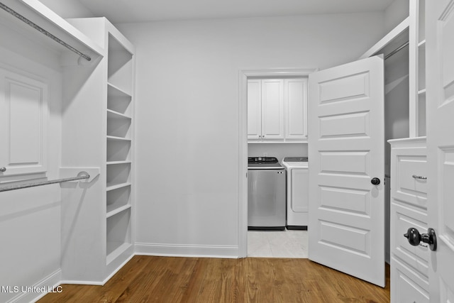 spacious closet featuring wood finished floors and separate washer and dryer