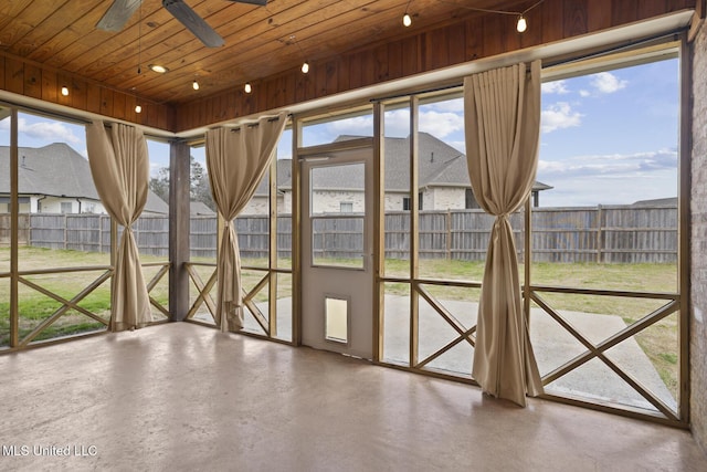 unfurnished sunroom with wood ceiling and ceiling fan