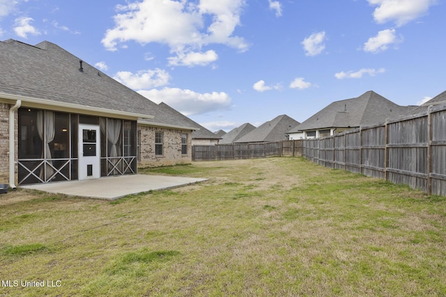 view of yard with a patio area, a fenced backyard, and a sunroom